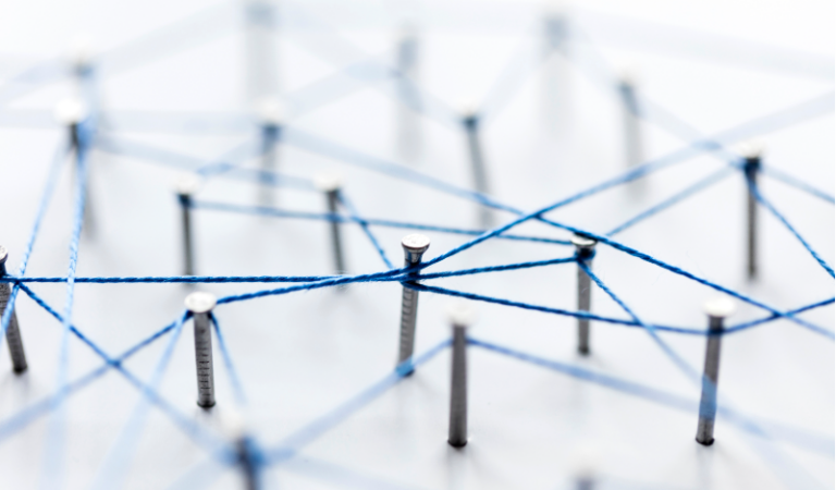 Photo of nails on a board with blue string connecting the heads.