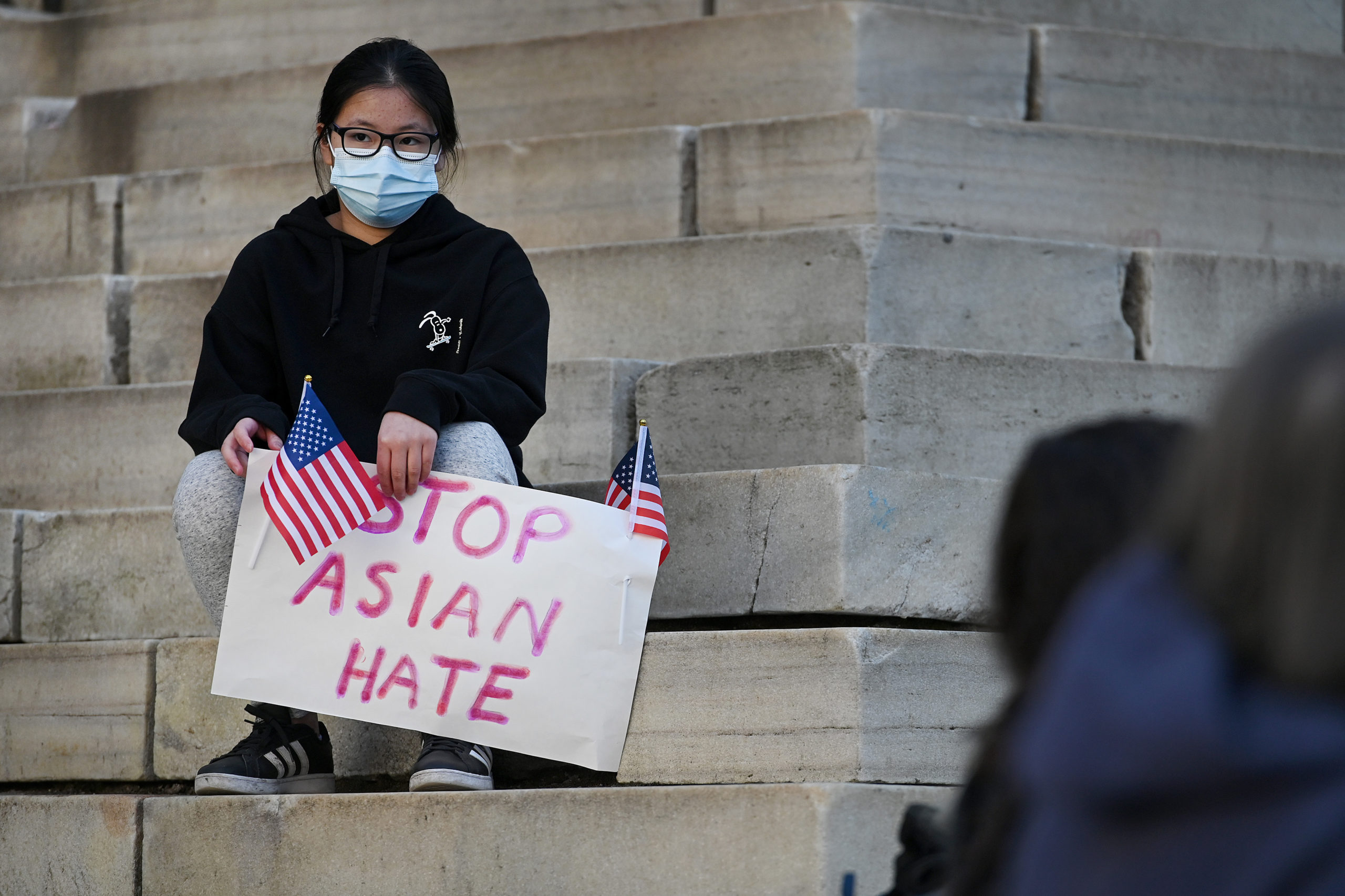 Photo of a girl holding a sign that says "Stop Asian Hate"