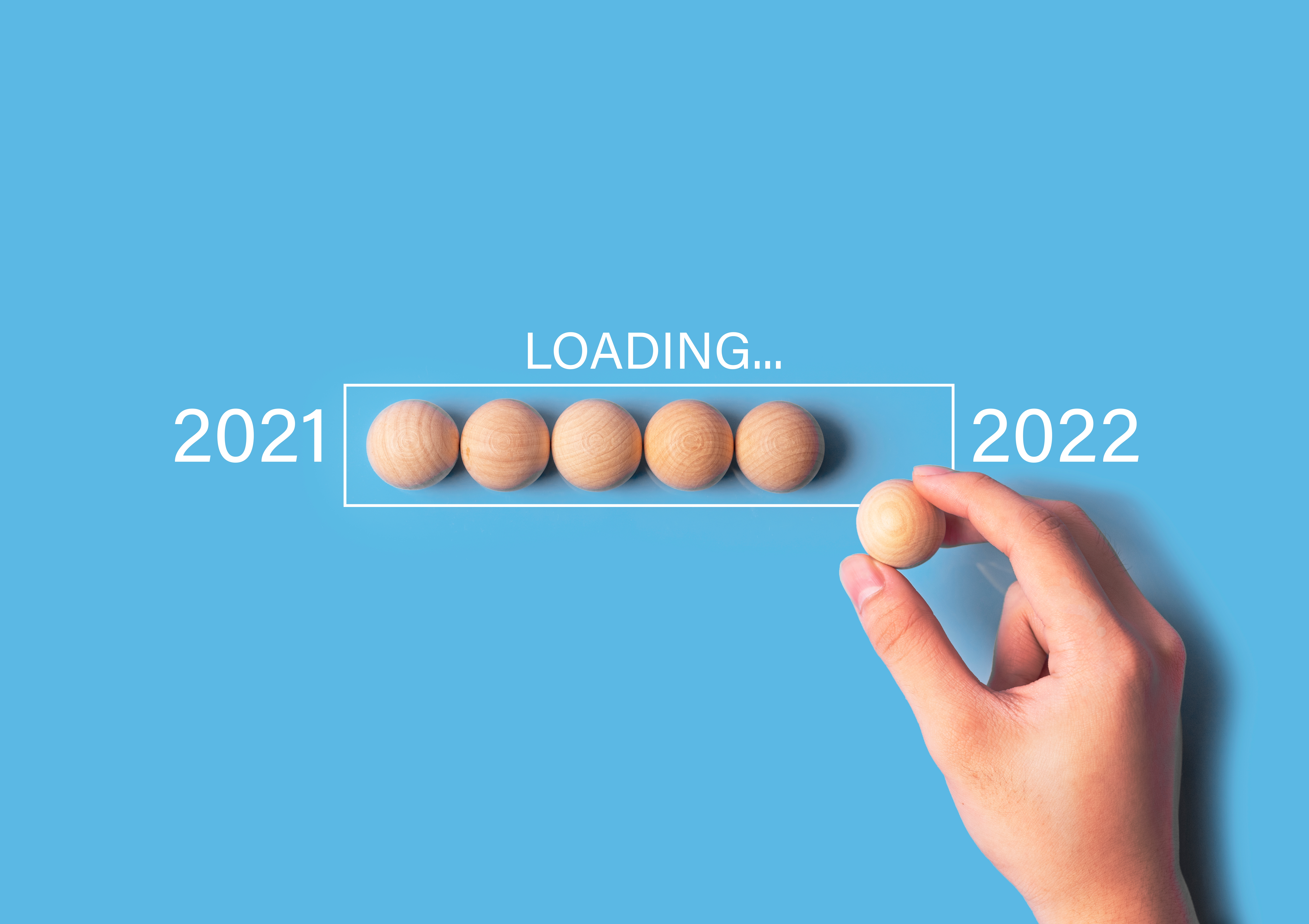 start and countdown concept. Hand putting wood circle in loading progress bar for countdown year 2021 to 2022.