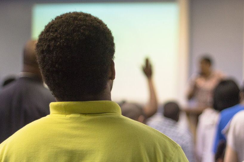 An African American teenager male attending church.