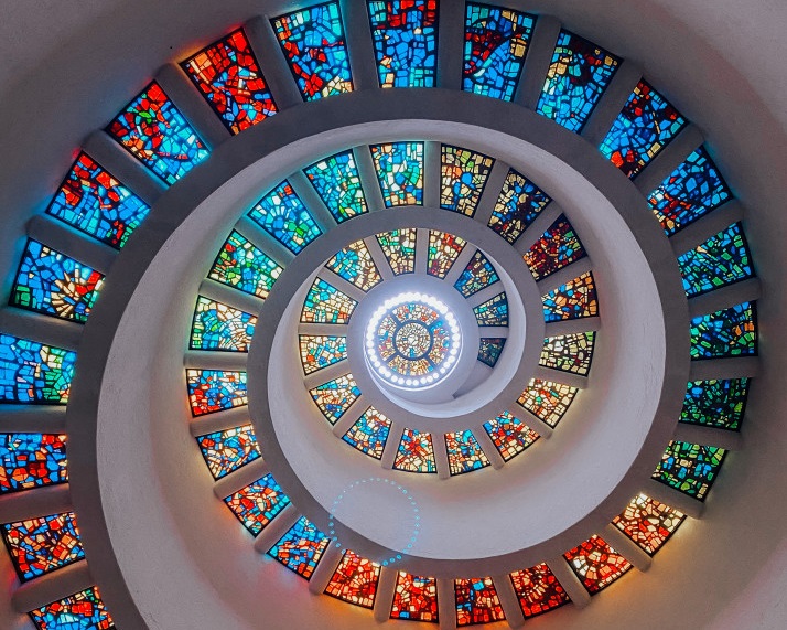 A photo of a spiral ceiling made up of mosaic glass windows.