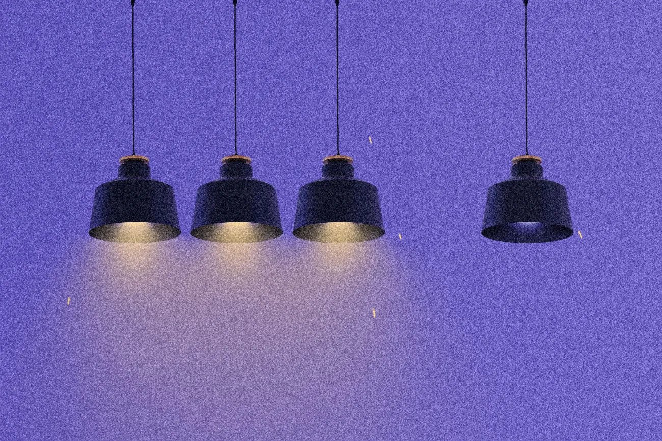 Four cartoon black hanging lamps on a blue background, one light bulb is not working.