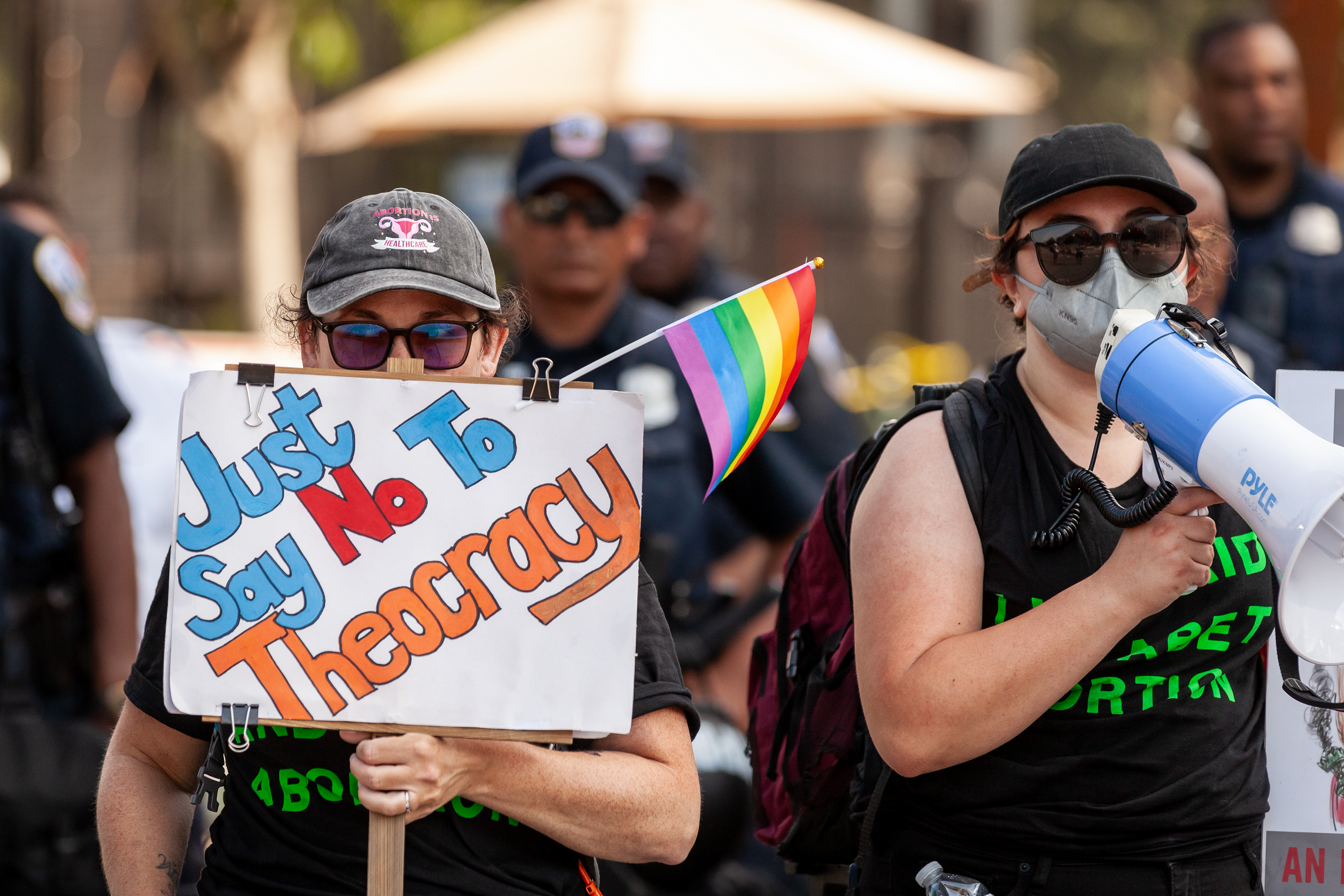 abortion rights protestors holding a sign reading "just say no to theocracy."