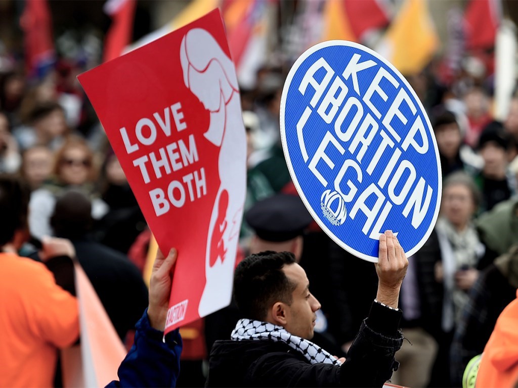 Abortion protesters gathered with "love them both" and "keep abortion legal" signs
