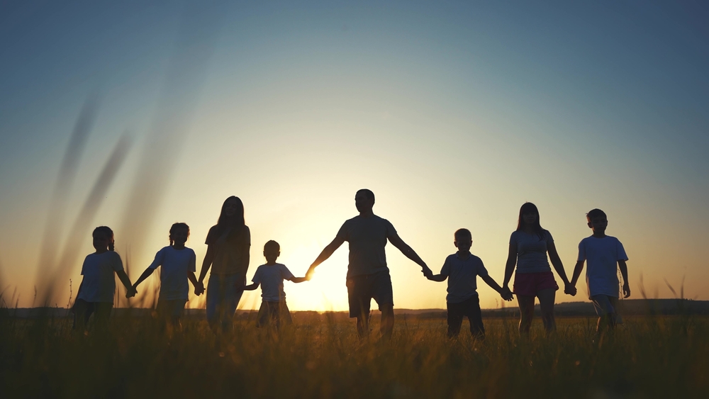 Family in wheat field at sunset